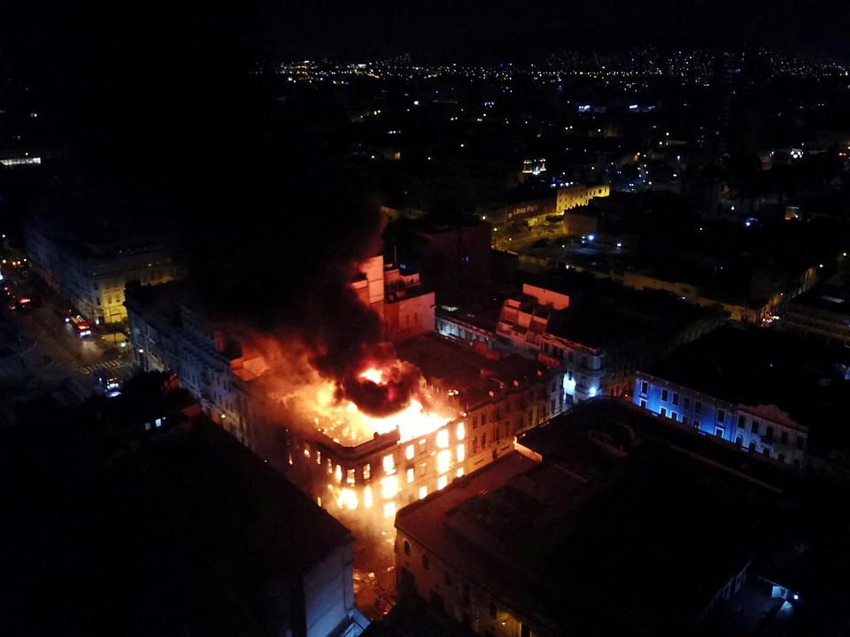 Smoke and flames rise from a building during the 'Take over Lima' march to demonstrate against Peru's President Dina Boluarte.