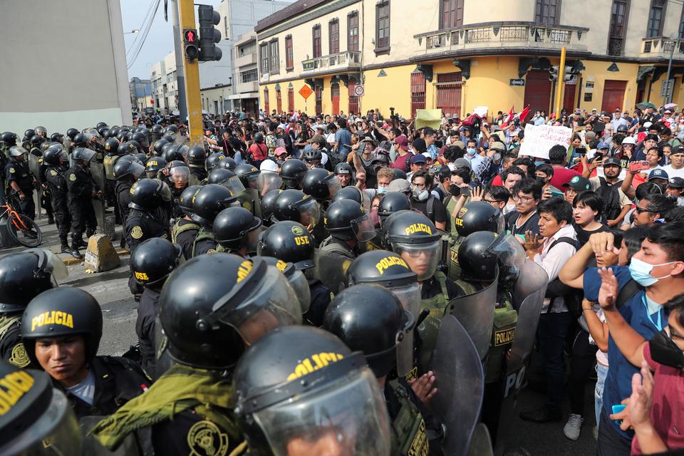 Police officers stand guard, as anti-government protesters demand the release of protesters detained in the protests, after President Pedro Castillo was ousted, in Lima.