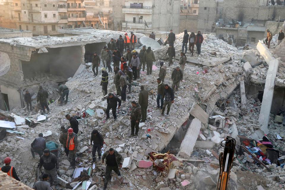 Civil defense workers and civilians work on the rubble of a destroyed building in the Sheikh Maksoud neighborhood in Aleppo, Syria.