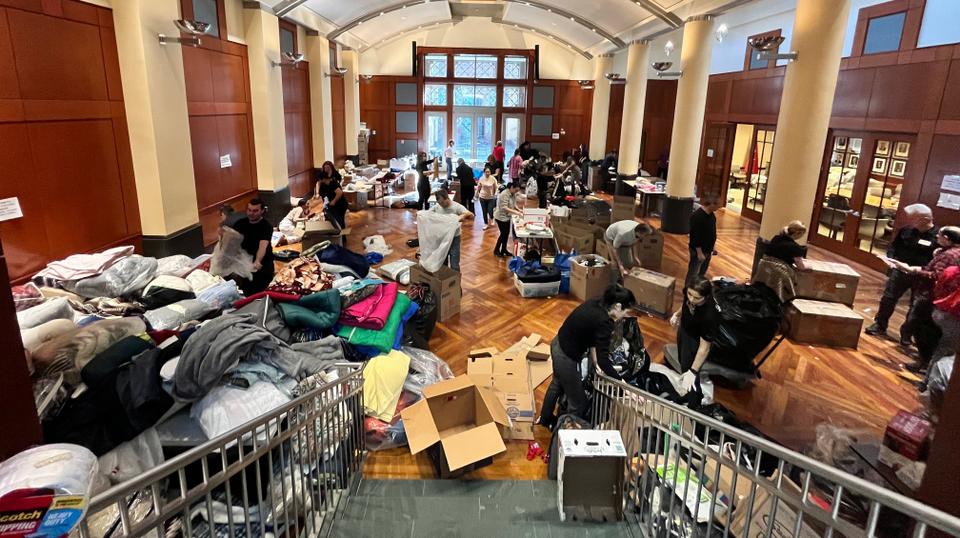 Volunteers segregate winter clothes, boots, blankets, sleeping bags, flashlights, power banks, tents, beds, canned food inside the Turkish embassy.