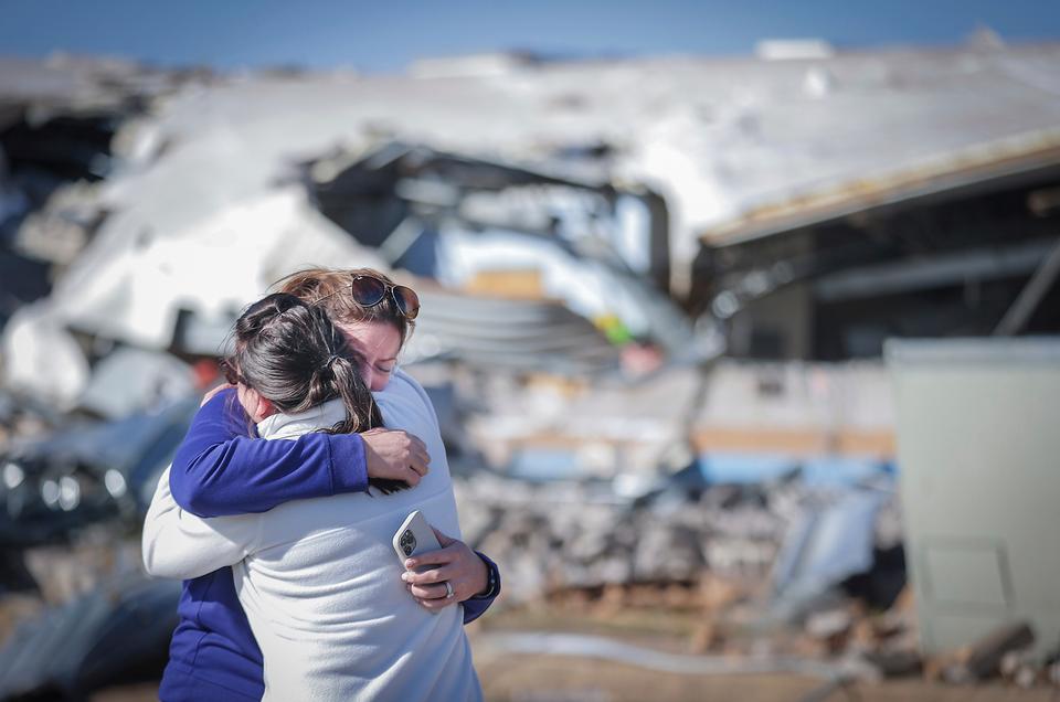 Crestview Elementary School teachers Anna Vandiver [L] and Elizabeth Woddell share a hug while visiting the mangled wreckage of their classrooms.