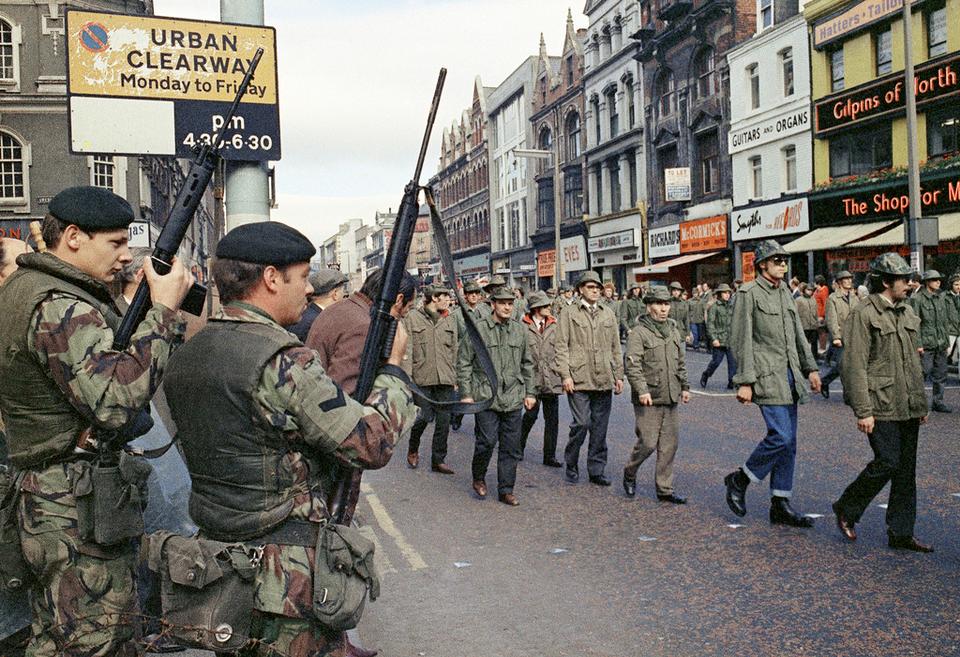 British troops watch as members of the Ulster Defence Association parade through Belfast, Northern Ireland, in August 1972.