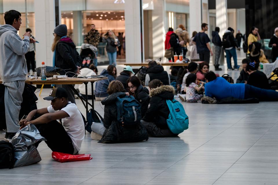 People charge their phones at stations set up in the CF Fairview Mall on April 07, 2023, in Montreal, Canada after freezing rain hit parts of Quebec and Ontario.