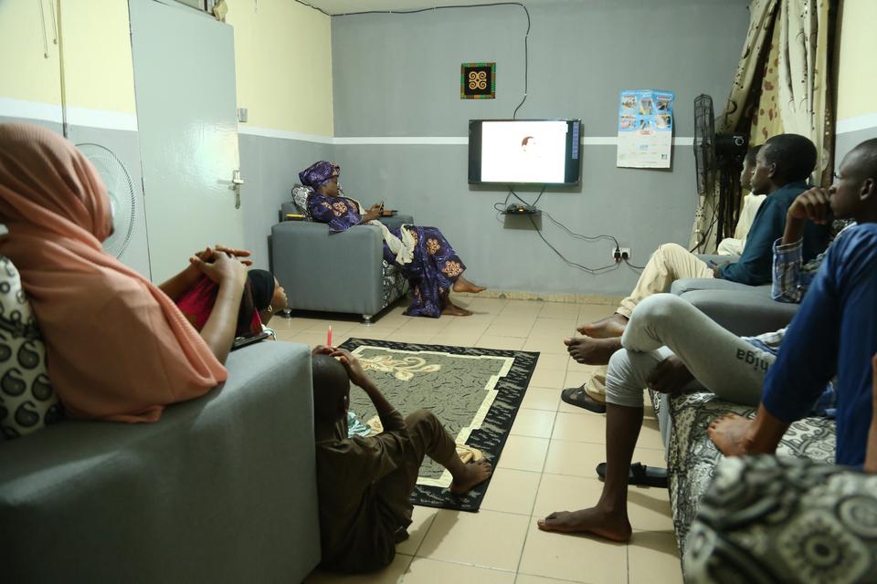 Families in Nigeria sit in group and watch Turkish series