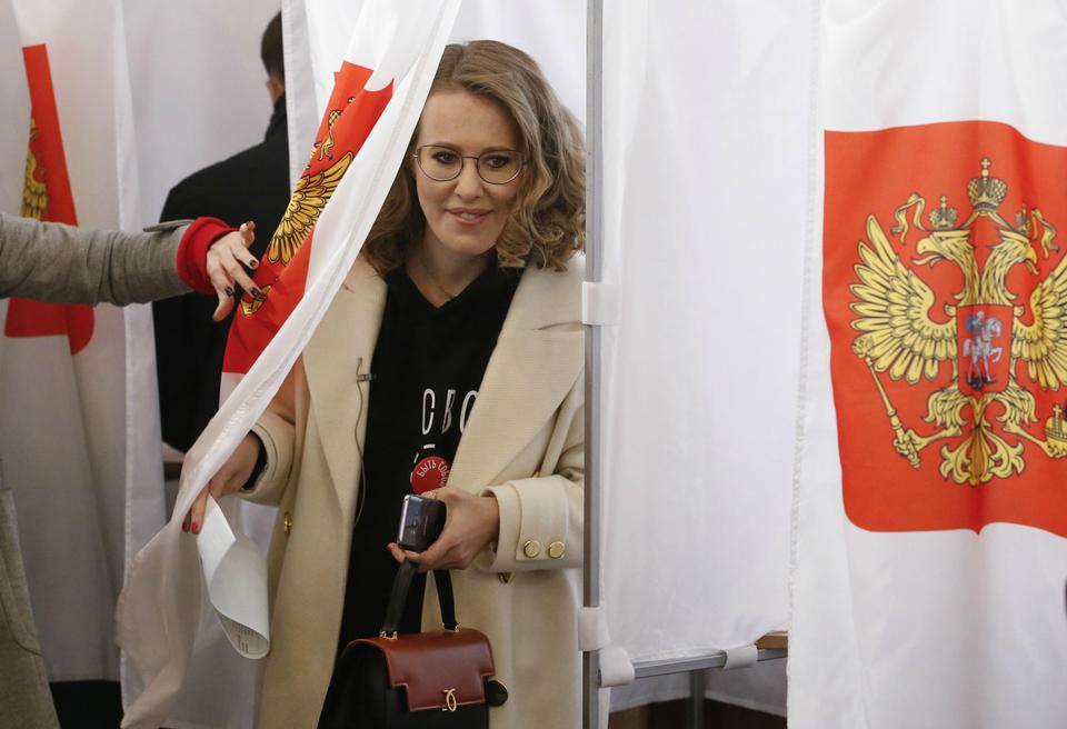 Presidential candidate Ksenia Sobchak walks out of a voting booth at a polling station during the presidential election in Moscow.