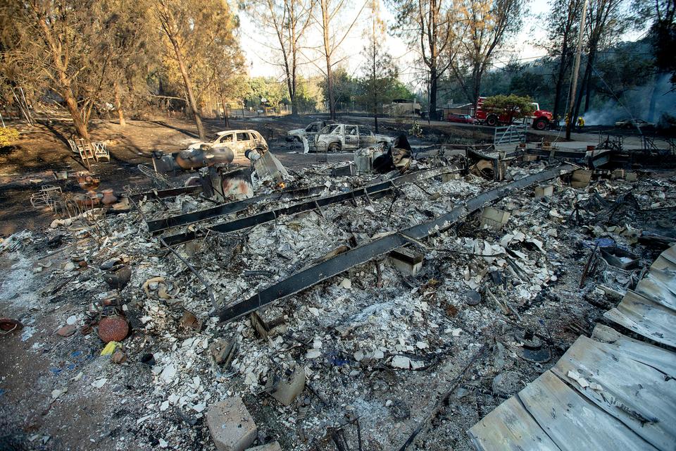 A structure leveled by a wildfire rests in a clearing on Wolf Creek Road near Clearlake Oaks, California, June 24, 2018.