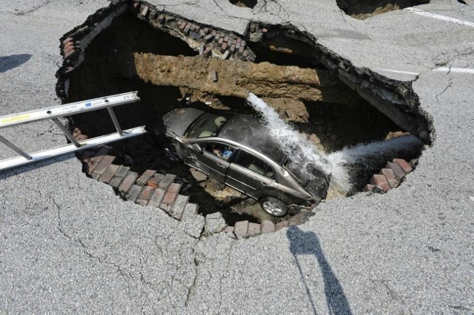 What are sinkholes and how are they caused?