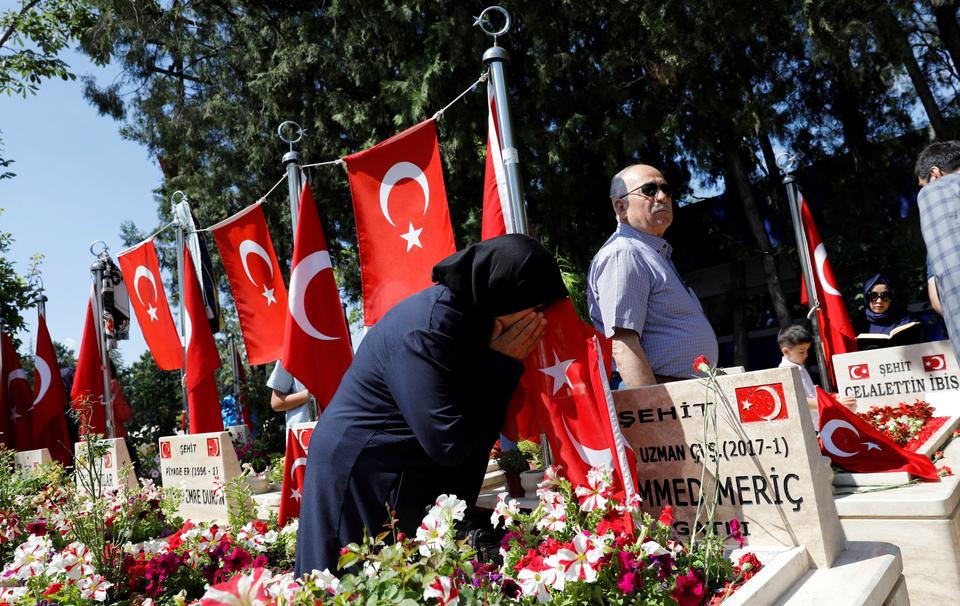 A woman mourns as she visits her son's grave who was killed during an attempted coup in 2016