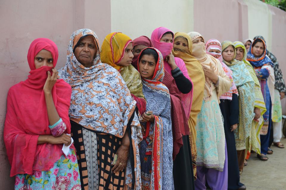 Pakistani women stand in a queue as they wait to cast their vote outside a polling station during general elections in Lahore on July 25, 2018.
