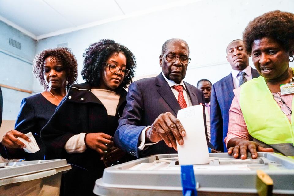 Former Zimbabwean president Robert Mugabe (C) his daughter Bona (C) and wife Grace cast their votes at a polling station at a primary school in the Highfield district of Harare during the country's general elections on July 30, 2018.