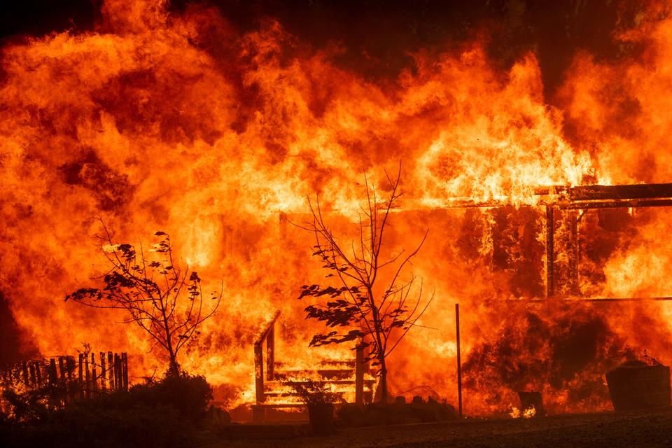 Flames consume a home as the River Fire tears though Lakeport, California., on Tuesday, July 31, 2018.