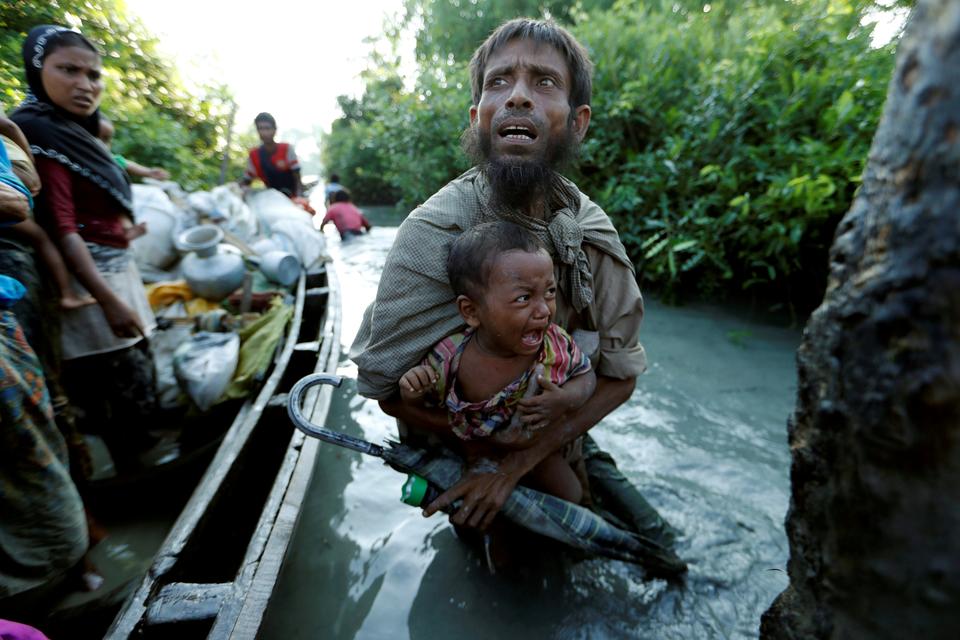 Rohingya refugees arrive to the Bangladeshi side of the Naf River after crossing the border from Myanmar.