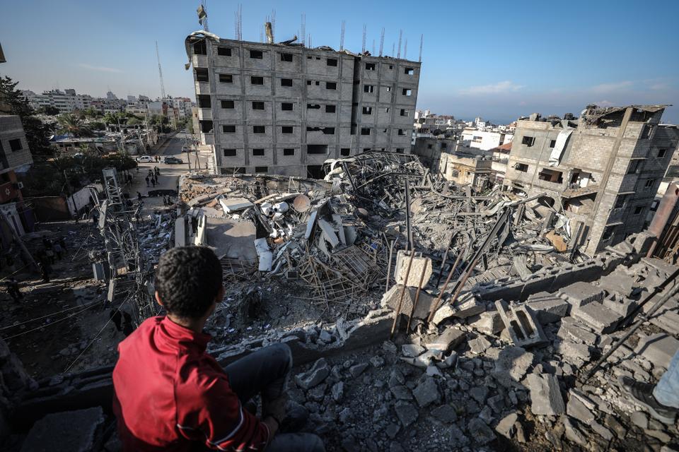 A Palestinian boy inspects the rubble of the Al Aqsa TV building after it was targeted by Israeli air strikes against Gaza, in Gaza City on November 13, 2018.