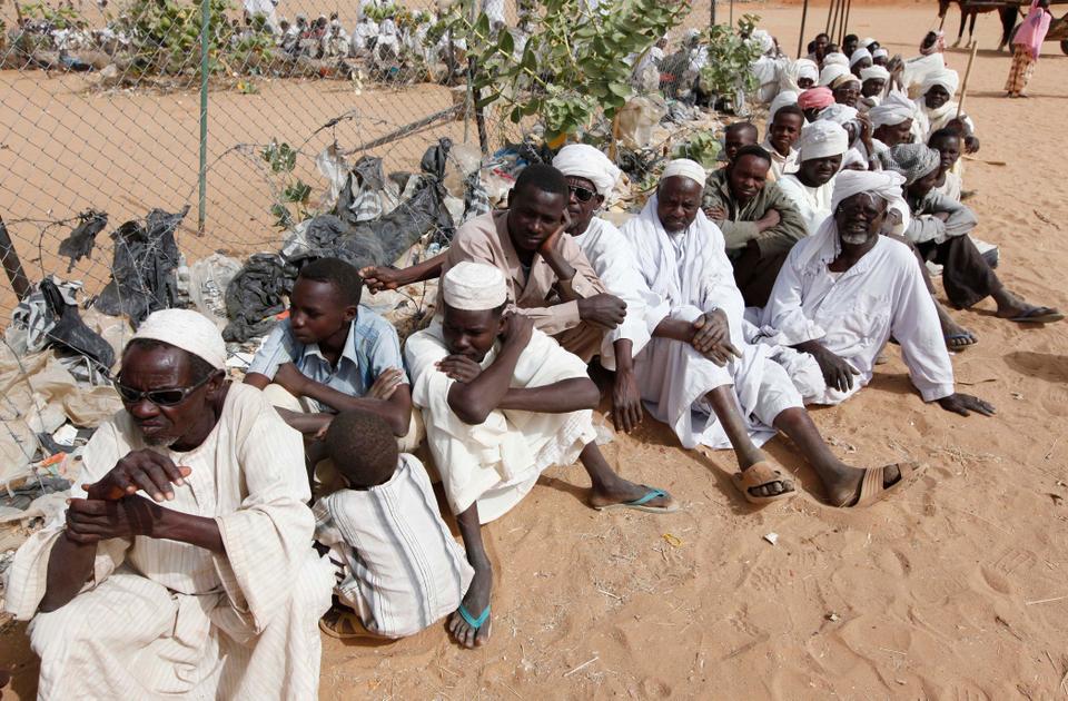 Displaced Sudanese men seeking medical treatment line up outside the Egyptian military field hospital at Abu Shouk refugee camp, outside the Darfur town of Al Fasher, Sudan, Thursday, March 26, 2009.