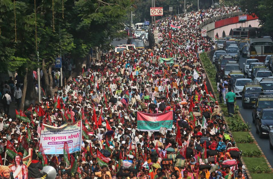 Farmers march on a flyover during a protest rally demanding loan waivers and the transfer of forest lands to villagers.