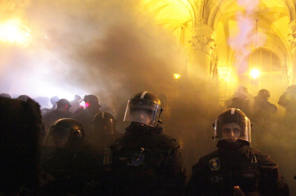 Riot police stand guard during a protest against the dubbed 