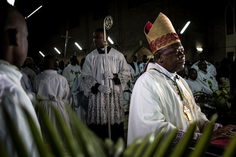 Archbishop of Kinshasa, Fridolin Ambongo Besungu (R), arrives at the start of Christmas Mass celebrations at the Notre Dame de Kinshasa cathedral.