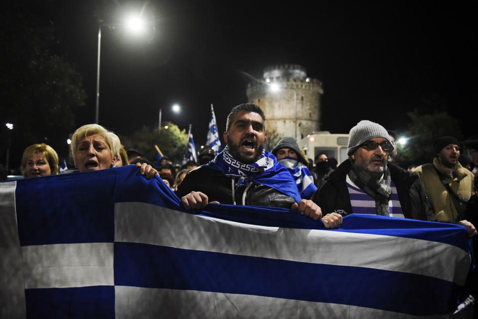 Holding a Greek flag, opponents of the Prespa Agreement chant slogans in a rally in the northern port city of Thessaloniki, Greece, Thursday, January 24, 2019.