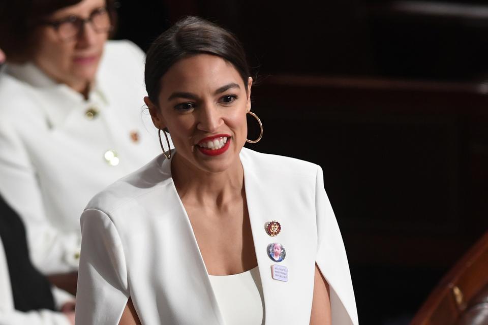 US Representative Alexandria Ocasio-Cortez (D-NY) smiles, dressed in white in tribute to the women's suffrage movement, as she arrives for the State of the Union address at the US Capitol in Washington, DC, on February 5, 2019.