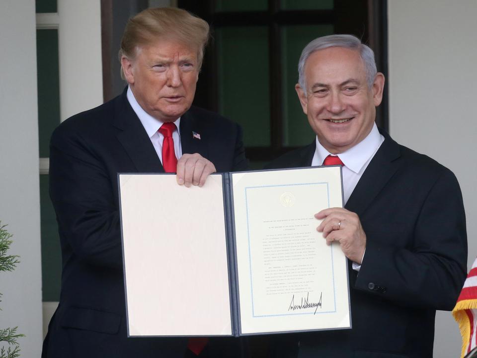 US President Donald Trump and Israel's Prime Minister Benjamin Netanyahu hold up a proclamation recognizing Israel's sovereignty over the Golan Heights as Netanyahu exits the White House from the West Wing in Washington, US March 25, 2019.
