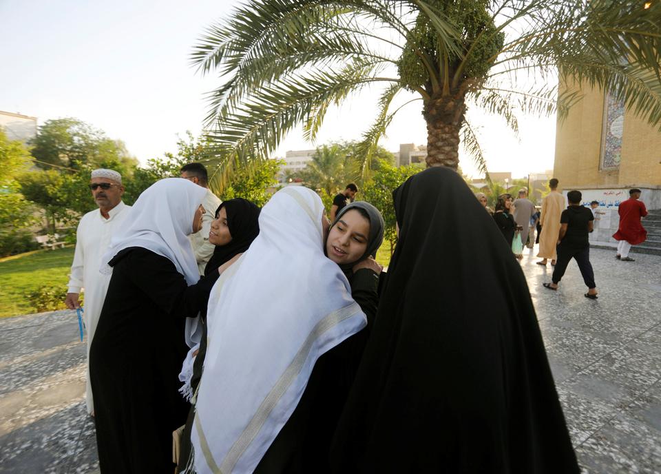 Muslim women greet each other outside a mosque in the Iraqi capital Baghdad [Khalid al-Mousily]