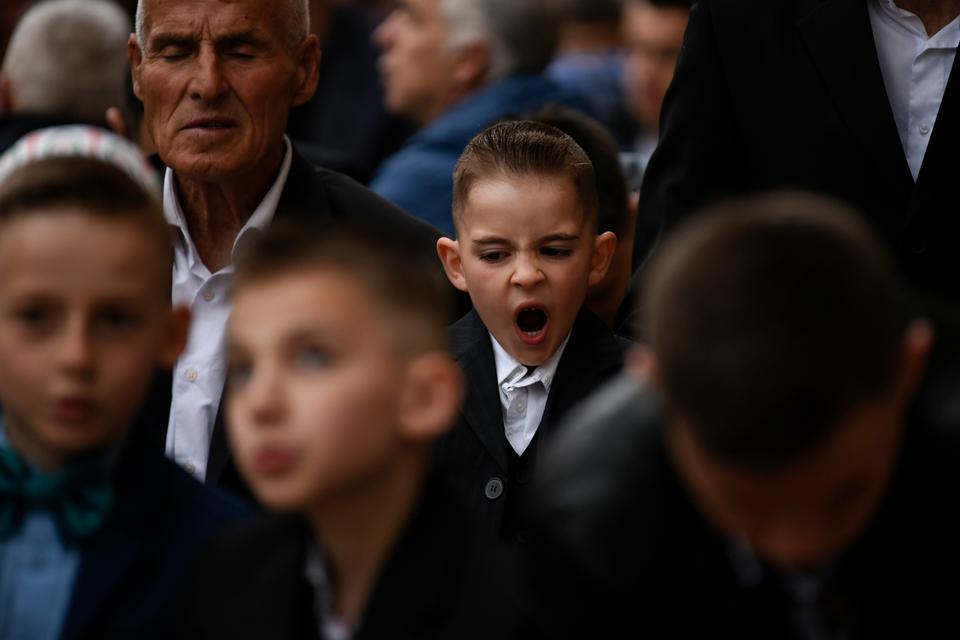 A young Kosovan boy yawns as he performs Eid al-Fitr prayers at the grand mosque in Pristina [Armend Nimani]