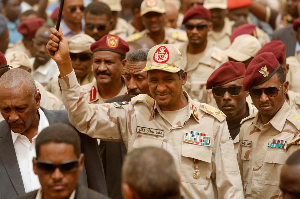 Gen. Mohammed Hamdan Dagalo, the deputy head of the military council, better known as Hemedti, center, escorted by his bodyguards, as he waves to his supporters during a military-backed rally, in Mayo district, south of Khartoum, Sudan, Saturday, June 29, 2019. Sudan's ruling generals say they have accepted a joint proposal from the African Union and Ethiopia to work toward a transitional government. (AP Photo/Hussein Malla)