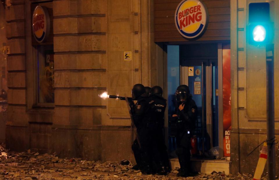 Riot police fire a weapon during Catalonia's general strike in Barcelona, Spain, October 18, 2019.