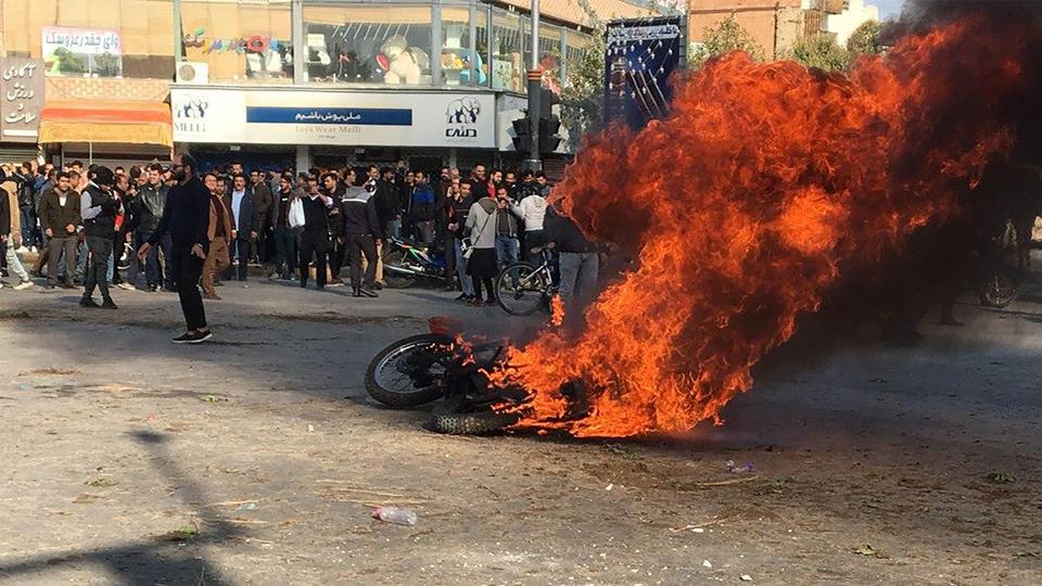 Iranian protesters gather around a burning motorcycle during a demonstration against an increase in gasoline prices in the central city of Isfahan, on November 16, 2019.