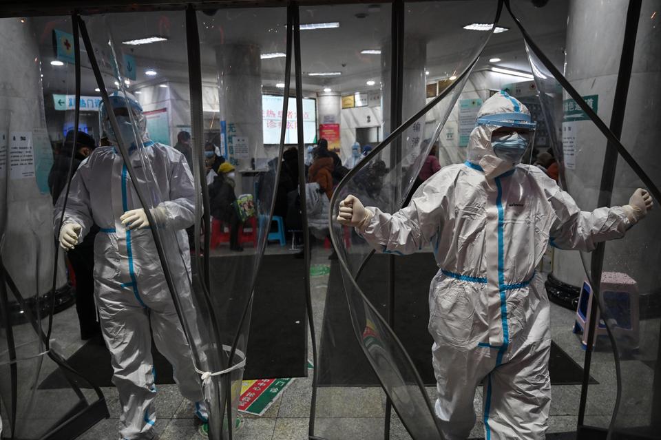Medical staff members wearing protective clothing to help stop the spread of a deadly virus which began in the city, walk at the Wuhan Red Cross Hospital in Wuhan on January 25, 2020.