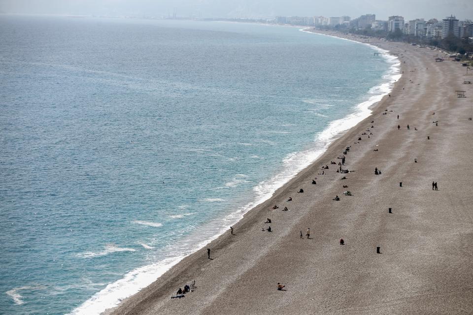 Few citizens are at the world-famous Konyaaltı beach, in Antalya, which is preferred by millions of people to swim every year. Those who want to sunbathe also paid attention to the distance between them.