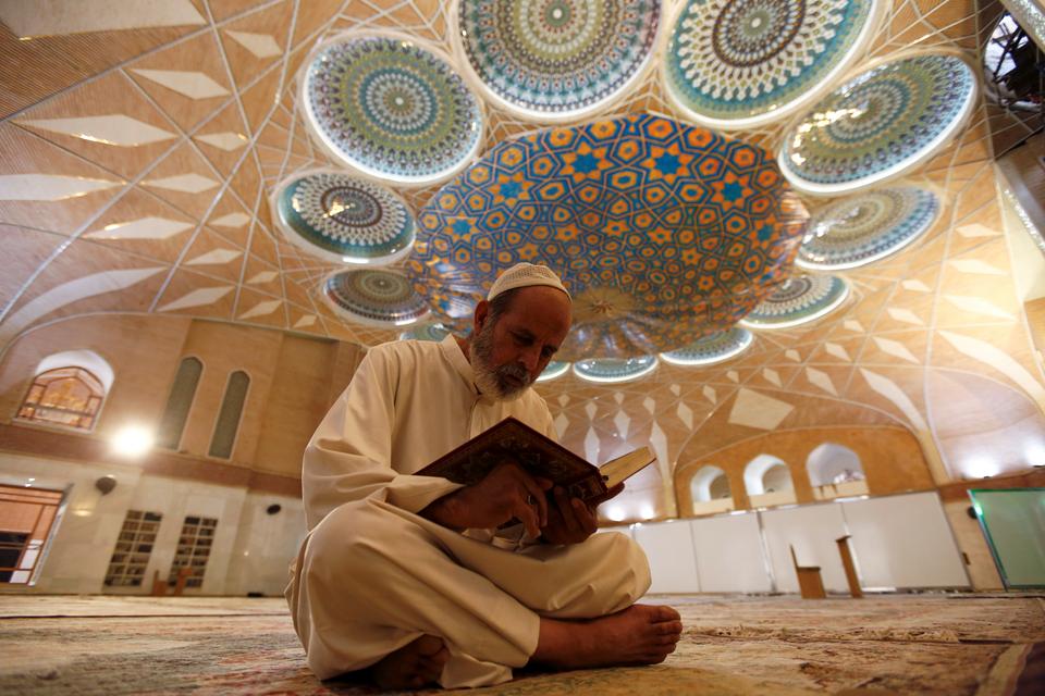 An Iraqi man reads the Koran in an almost empty mosque, following the outbreak of the coronavirus disease (COVID-19), during the holy month of Ramadan in the holy city of Najaf, Iraq April 29, 2020.