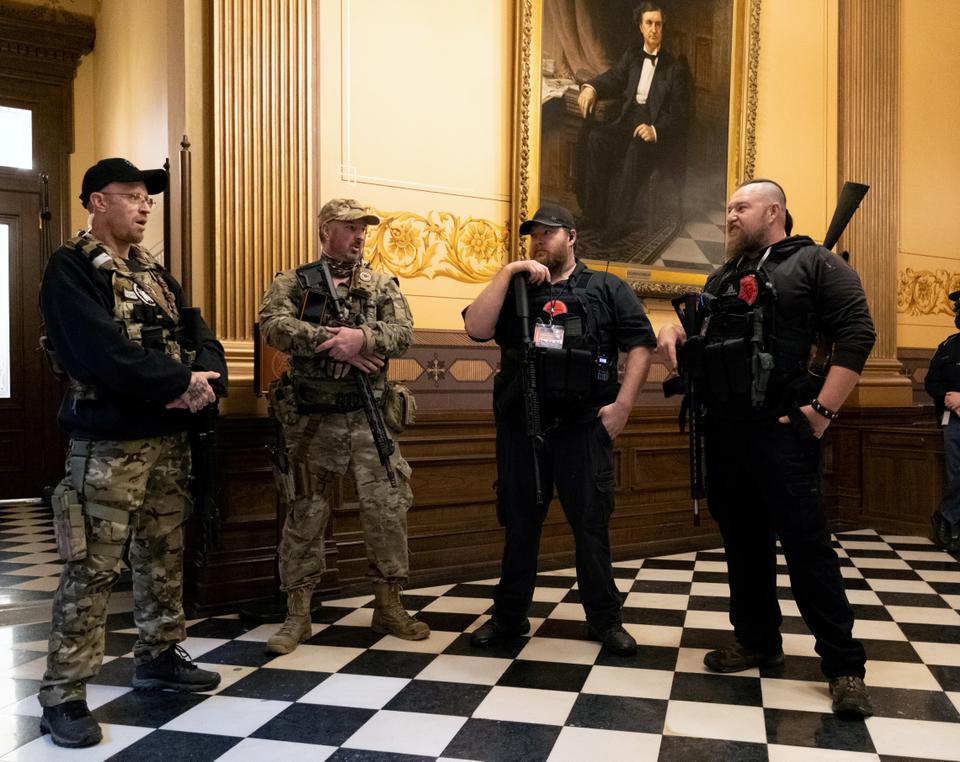 Members of a militia group stand near the doors to the chamber in the capitol building before the vote on the extension of Governor Gretchen Whitmer's emergency declaration/stay-at-home order due to the coronavirus disease (COVID-19) outbreak, in Lansing, Michigan, U.S. April 30, 2020.