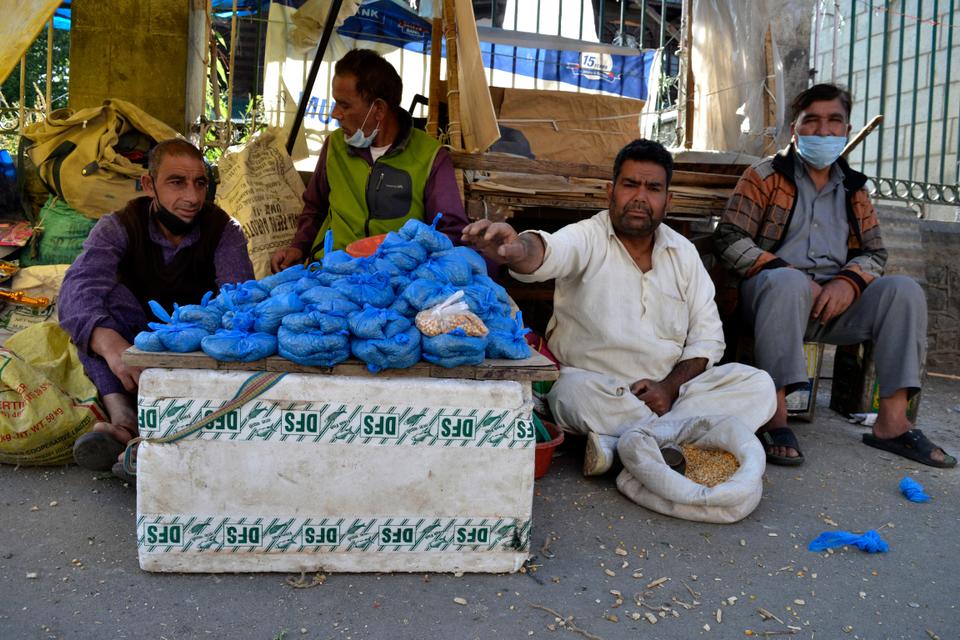 Ghulam Mohiudin sells dried corn outside a shrine in Srinagar, in India-administered Kashmir. Due to the repeated lockdowns in the region it had caused unemployment and given setback to the region’s economy. While there have been relaxations at many places in India, the strict restrictions in Kashmir continue due to coronavirus.