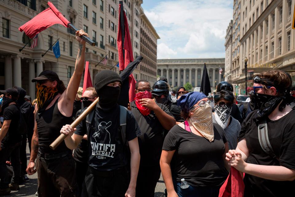 Members of an anti-fascist or Antifa march as the alt-right or far-right hold a 