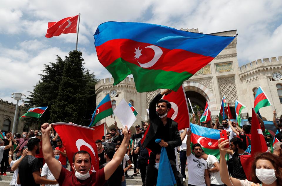 Azeri men living in Turkey wave flags of Turkey and Azerbaijan during a protest following clashes between Azerbaijan and Armenia, in Istanbul, Turkey, July 19, 2020.