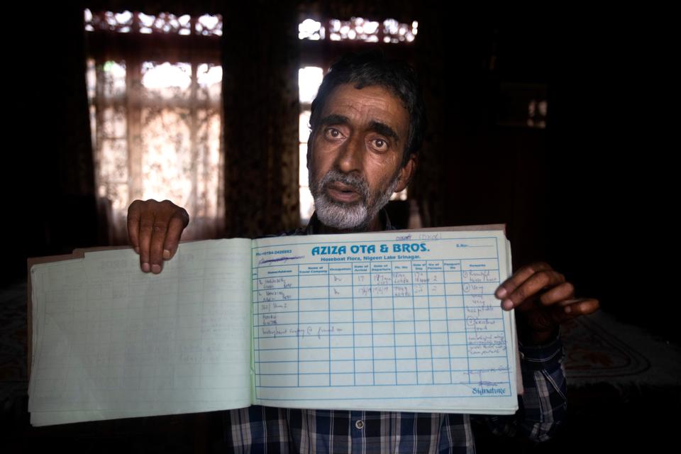 A Kashmiri houseboat owner, Ghulam Qadir, shows his guest entry book which was last filled in July 2019, in Srinagar, Indian-controlled Kashmir,Tuesday, July 28, 2020.