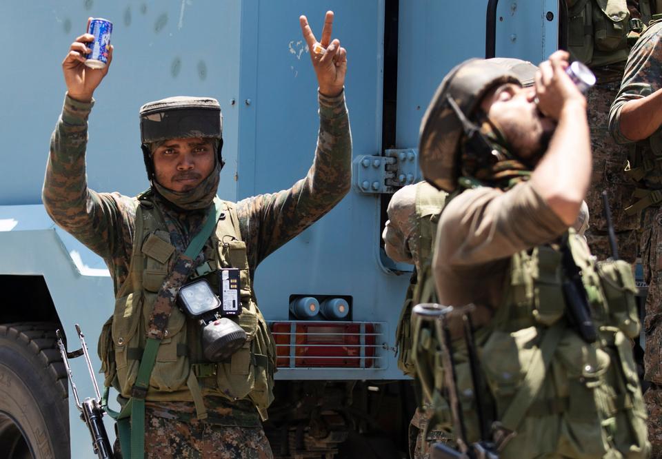Indian soldiers make the victory sign as they return from the site of a gun-battle in Srinagar, Indian-controlled Kashmir, Sunday, June 21, 2020.