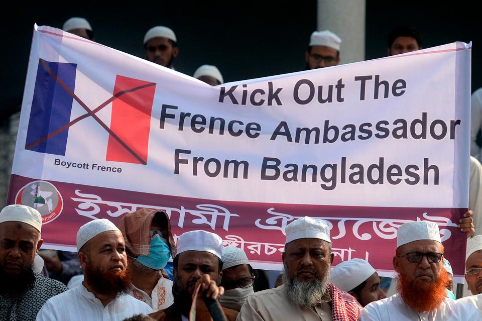 Protesters from a political party hold a banner during a demonstration calling for a boycott of French products and denouncing French President Emmanuel Macron, in Dhaka, Bangladesh, October 28, 2020.