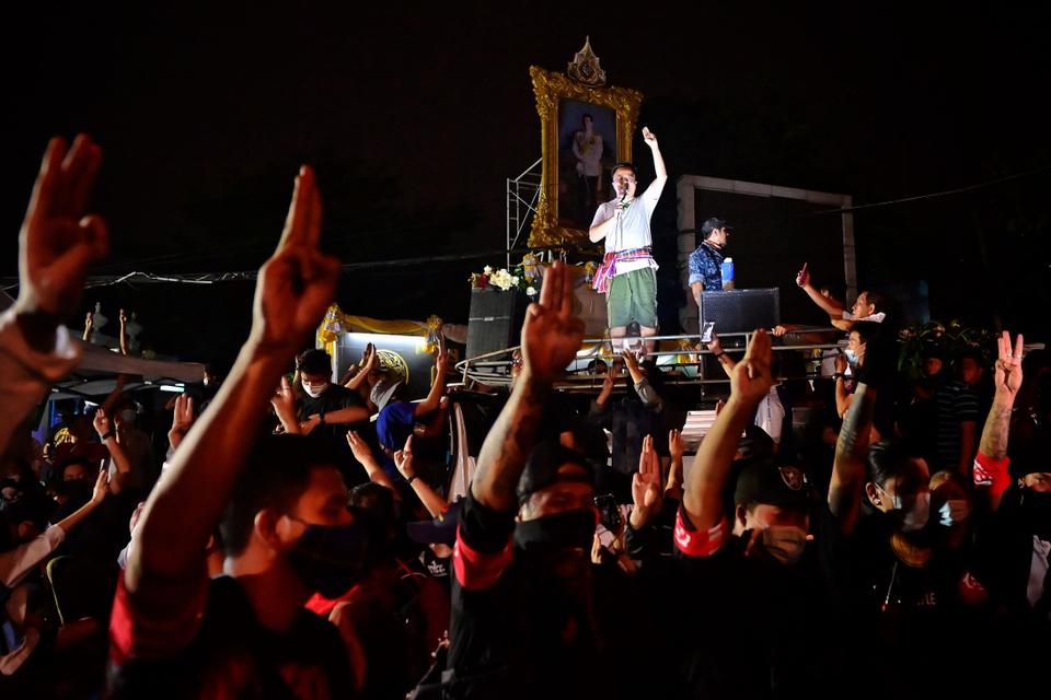 Protesters flash the three-fingered Hunger Games salute as Thai lawyer and activist Anon Numpa speaks after he and three others were released from Bangkok Remand Prison in the early hours of November 3, 2020,.