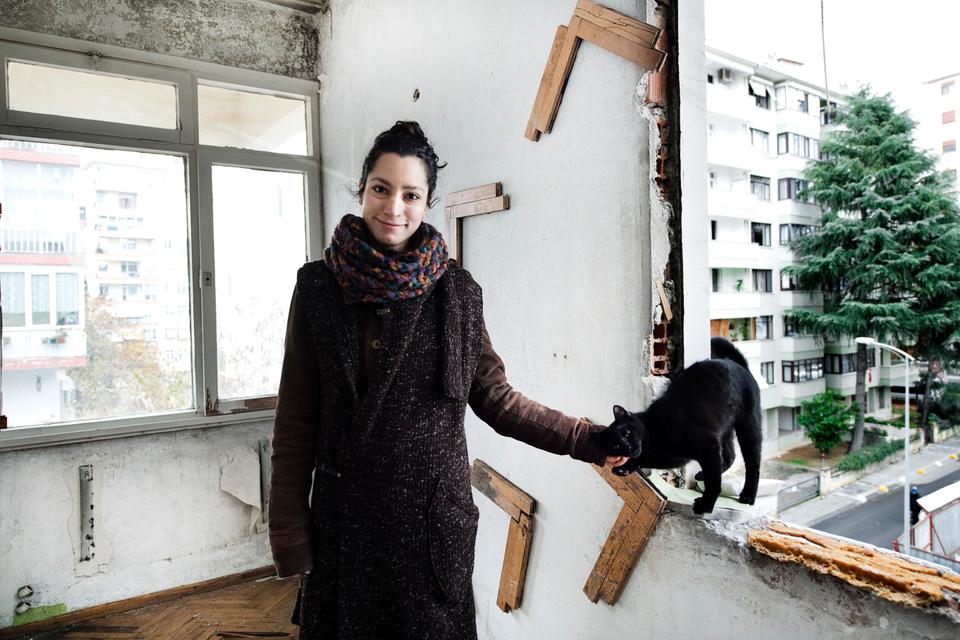 Curator and sculptor Begum Tekay with one of the neighbourhood felines.