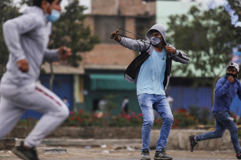 An agricultural worker uses a slingshot after clashes erupted during a protest demanding higher incomes in Viru, 510 km north of Lima, on December 30, 2020.