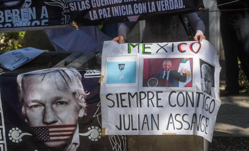 A Mexican activist holds a sign that reads 