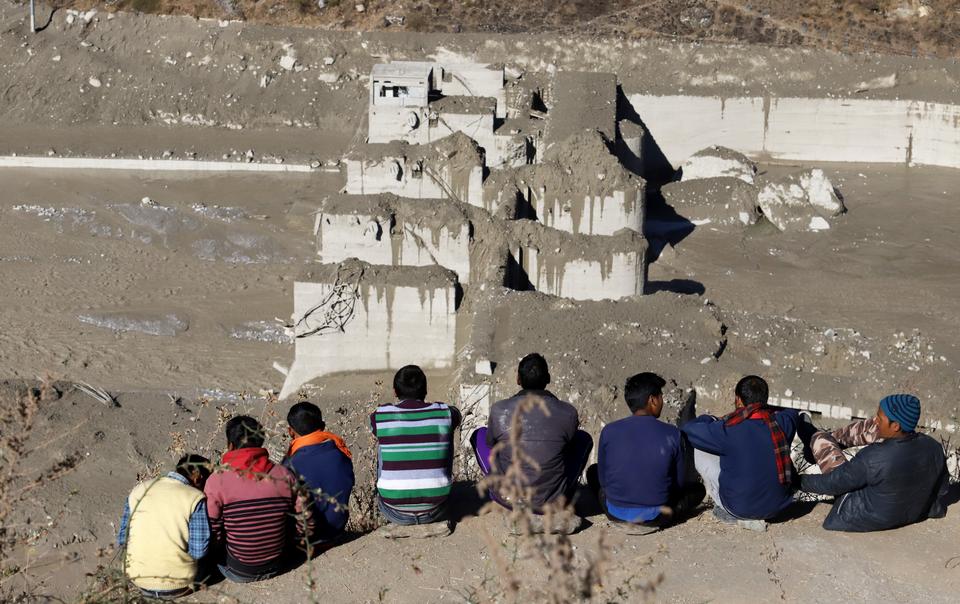 People watch search and rescue operations near the damaged Dhauliganga hydro power project in Chamoli district, Uttarakhand, India.