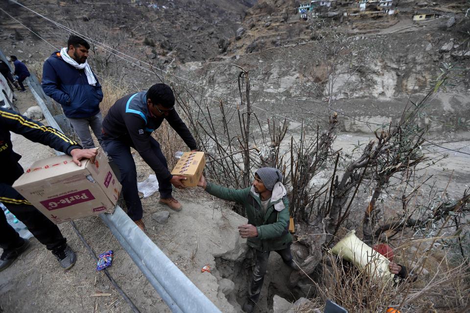 Relief material is being transported manually.
