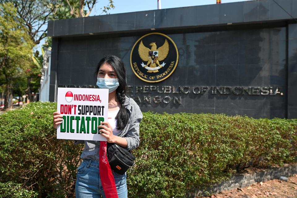 A demonstrator holds a placard during a rally against the military coup in front of the Indonesian Embassy in Yangon, Myanmar, February 24, 2021.